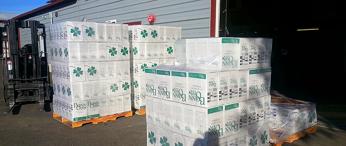 Pallets stacked with cases of Bonn Óir Gold Medal Vodka beside a forklift