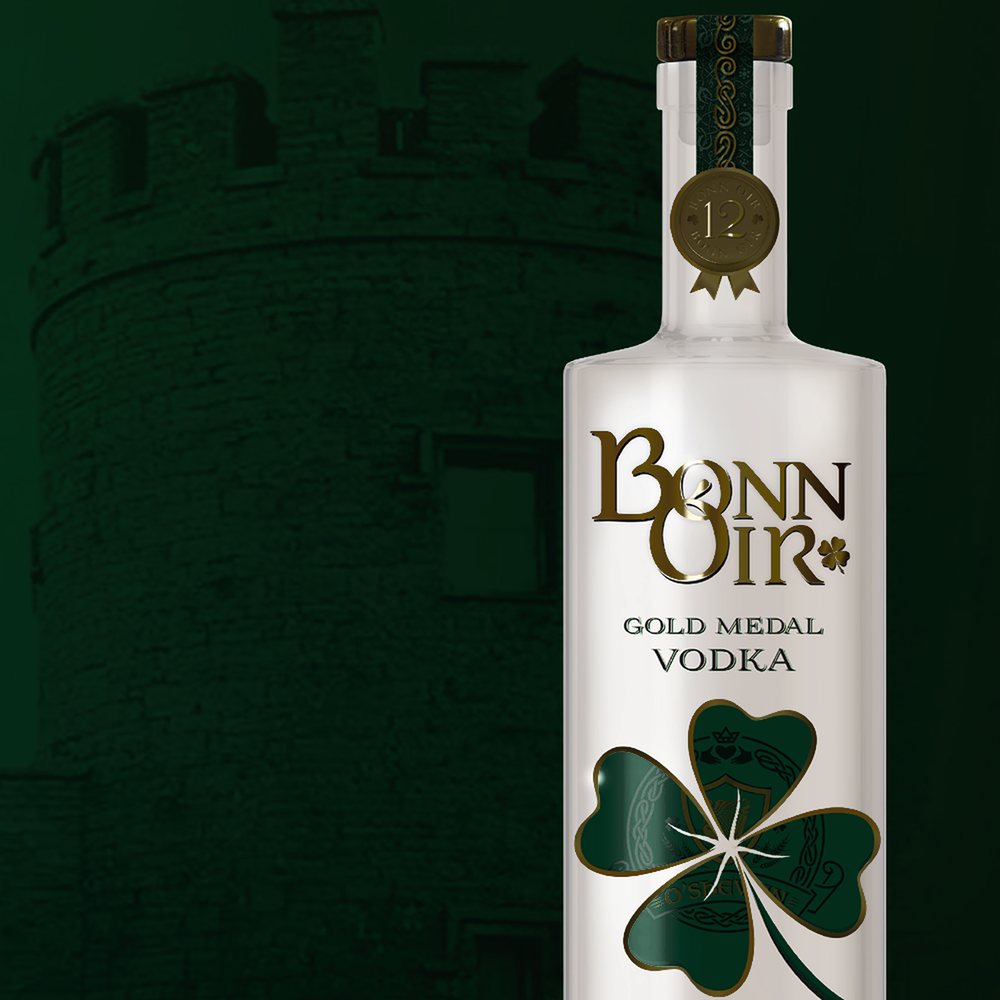 A bottle of Bonn Óir Gold Medal Vodka in front of an Irish stone tower